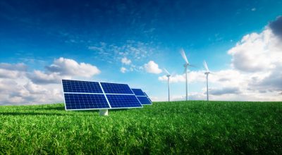 Solar panels and wind turbines against a clear sky.