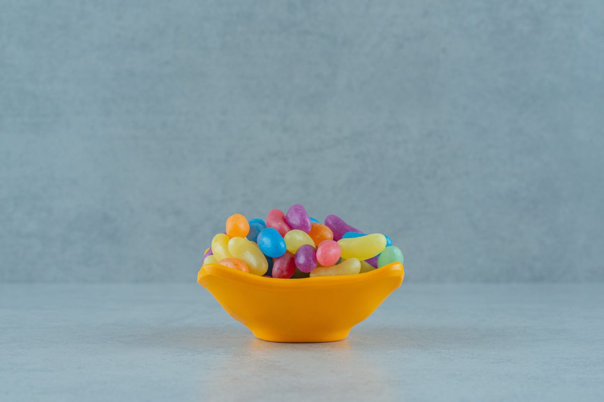 A vibrant assortment of fiber gummies for adults, displayed in a bowl on a table, tempting with their colorful jelly bean appearance.